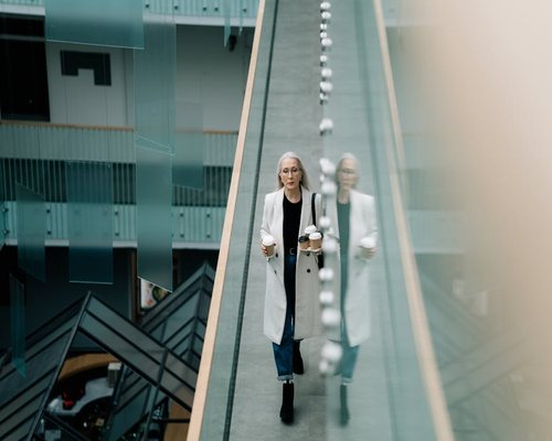 person taking a short walking break in a bright office corridor